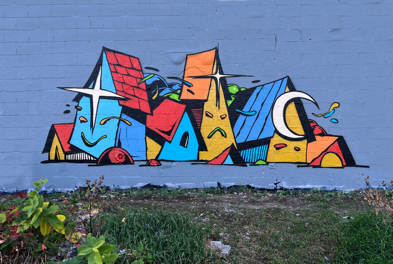 Une murale représentant des maisons personnifiées, sous forme de composition graffiti